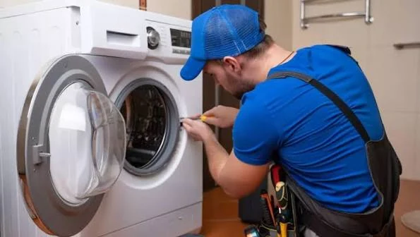 Technician examining the door opening of a front-loading washing machine